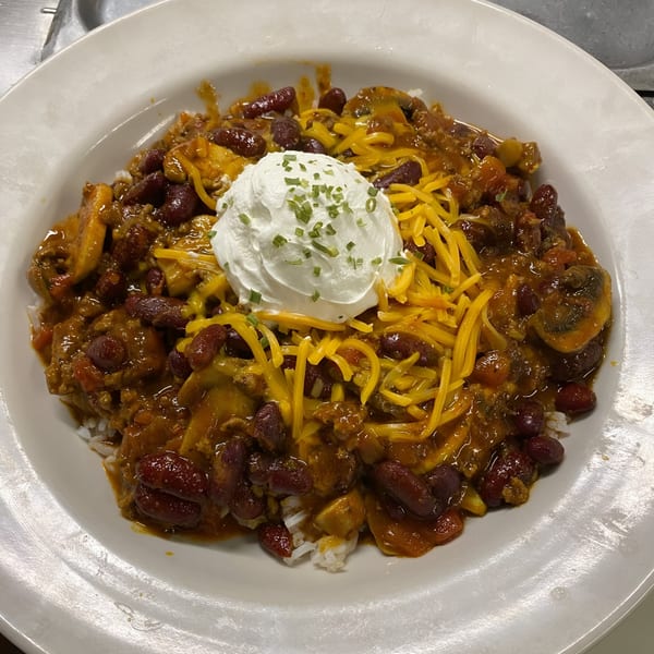 Hearty chili with kidney beans, shredded cheese, and a dollop of sour cream with chives.